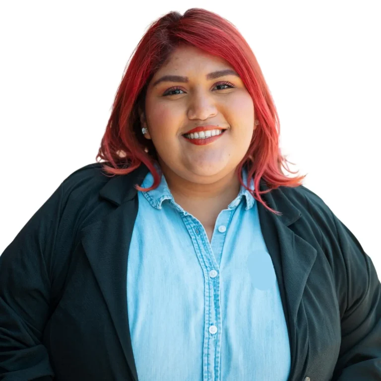 woman in business attire smiling in front of white backdrop