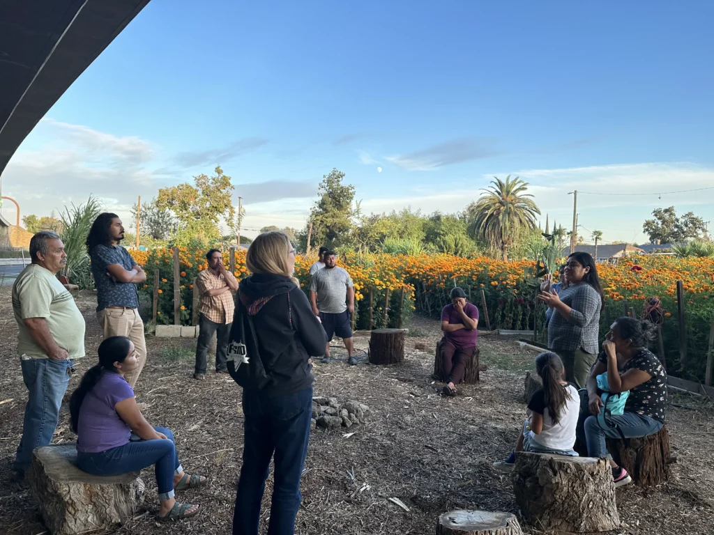 group of people meeting in community garden in large circle