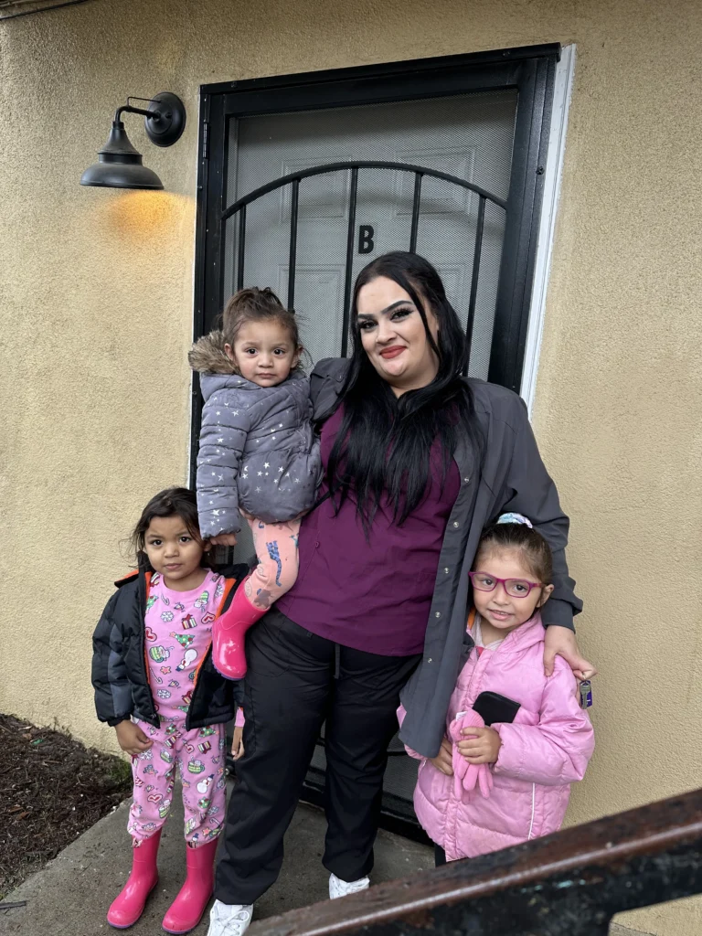 mother with her three children in front of her home
