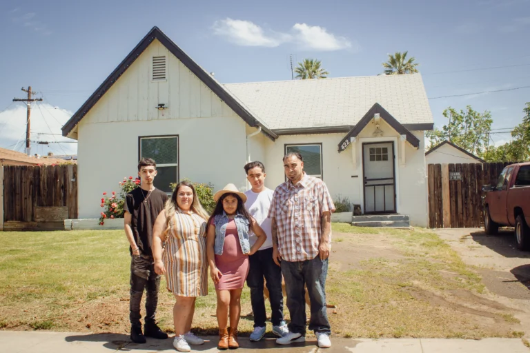 family of five in front yard of their home