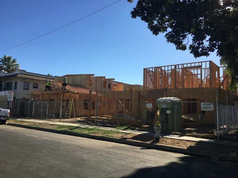 construction site where framing of apartment complex is shown next to street
