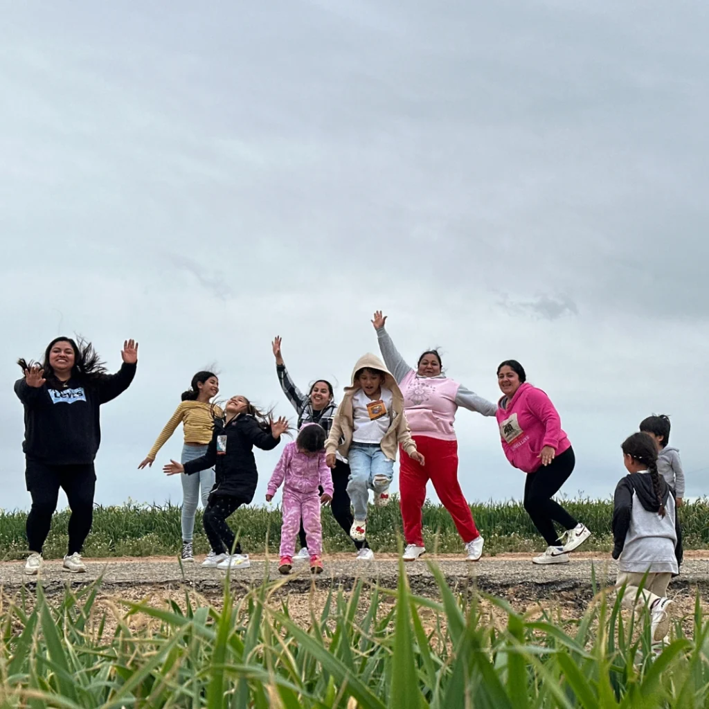 group of kids mid jump with grass in foreground