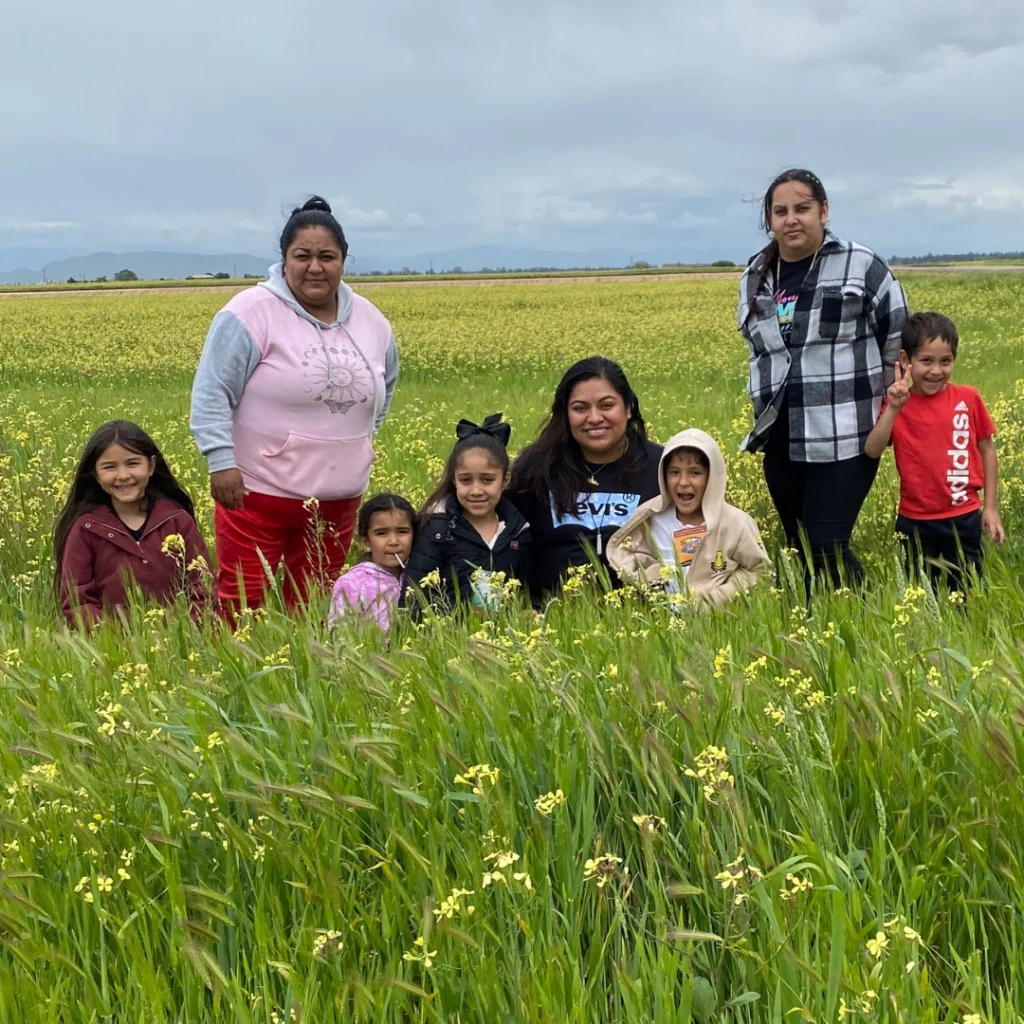 group of people sitting and standing in wildflower field