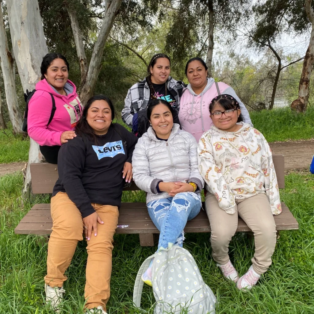 group of girls sitting on picnic table outdoors