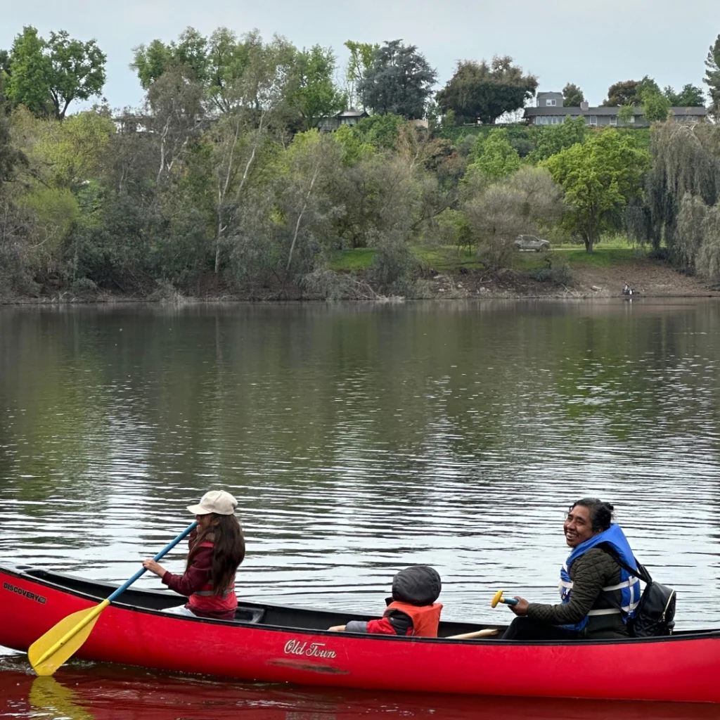 three kids canoeing on a lake