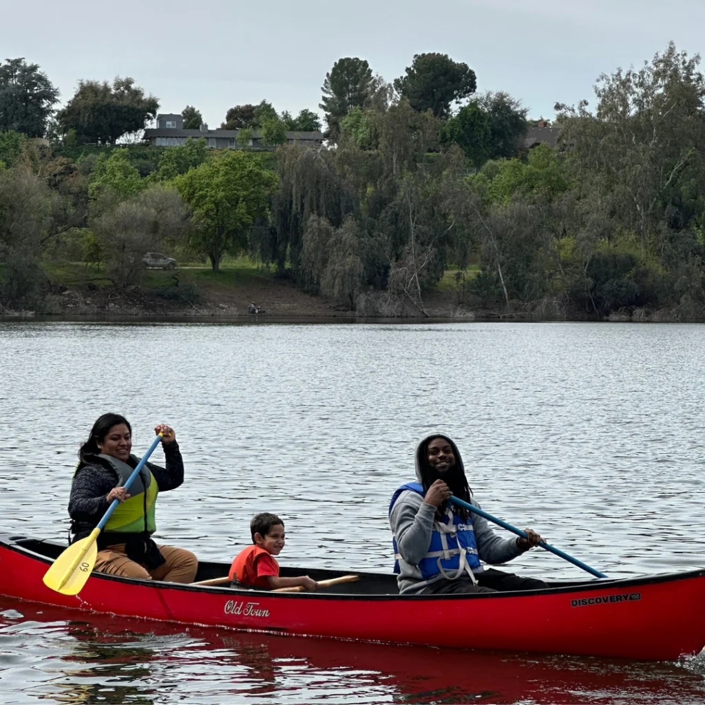 three kids canoeing on a lake