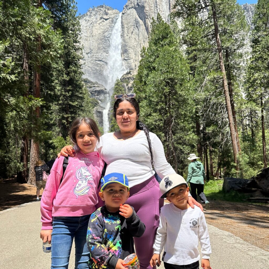 family in front of trees and waterfall
