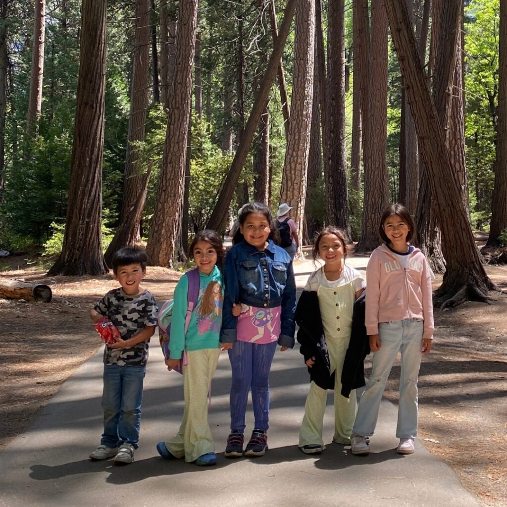 five kids standing on path in forest