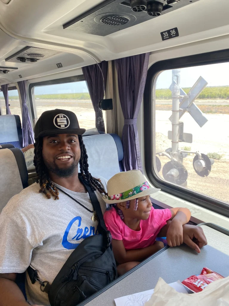 child and father smiling at the camera and looking out the window smilling