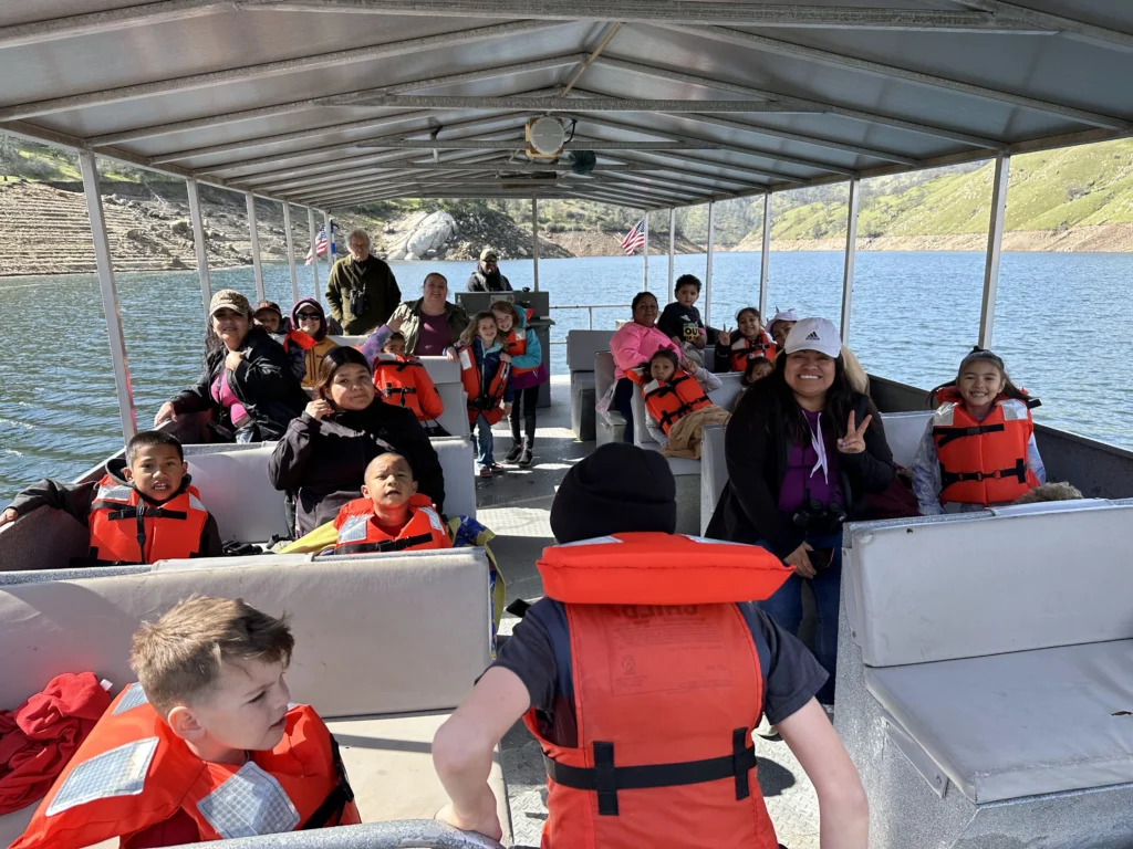 group of people wearing life jackets on covered boat